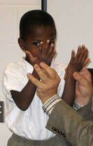 Teacher holding student's hands